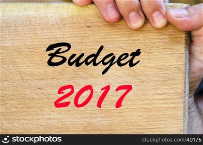 Human hand over wooden background and budget 2017 text concept