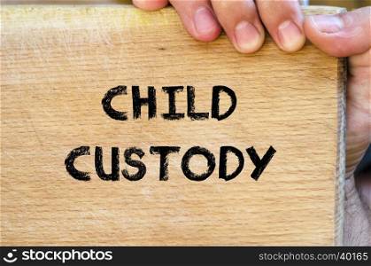 Human hand over wooden background and child custody text concept