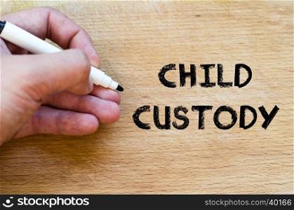 Human hand over wooden background and child custody text concept