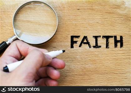 Human hand over wooden background and faith text concept