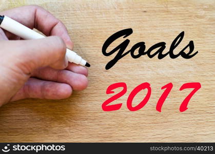 Human hand over wooden background and goals 2017 text concept