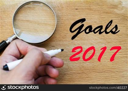 Human hand over wooden background and goals 2017 text concept