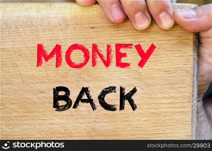 Human hand over wooden background and money back text concept