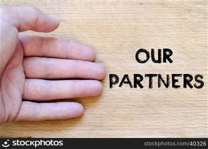 Human hand over wooden background and our partners text concept