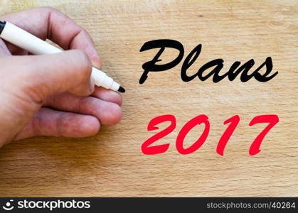 Human hand over wooden background and plans 2017 text concept