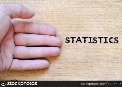 Human hand over wooden background and statistics text concept