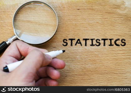 Human hand over wooden background and statistics text concept
