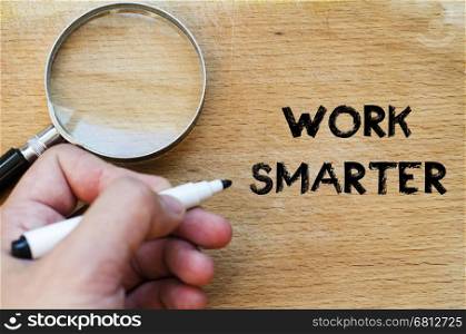 Human hand over wooden background and work smarter text concept