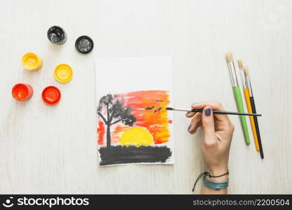 human hand painting beautiful nature sunset seen paper with water colors