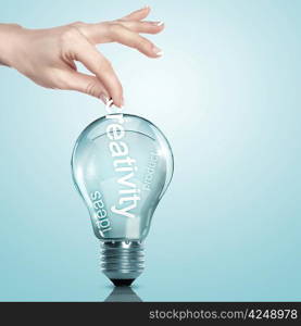 Human hand putting word Information inside a light bulb