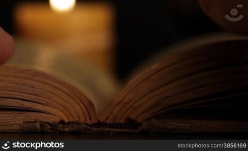 human hand turns over page of the book.