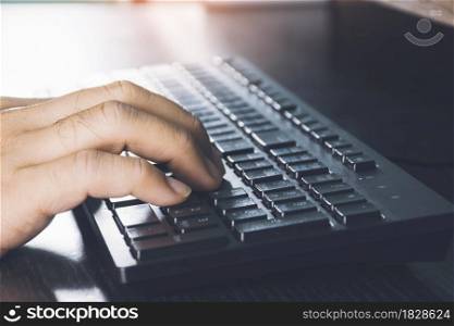 Human hand using computer keyboard on desk