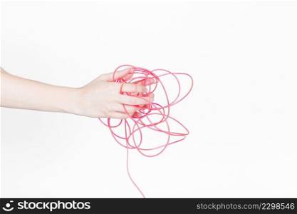 human hand with tangled red wire