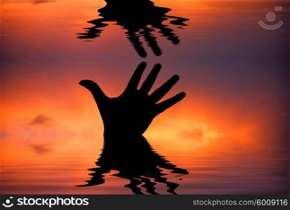 human hand with water reflection at sunset