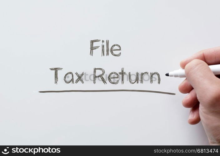 Human hand writing file tax return on whiteboard