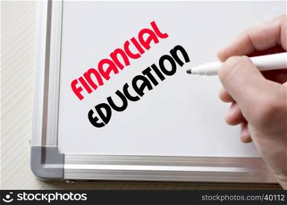 Human hand writing financial education on whiteboard