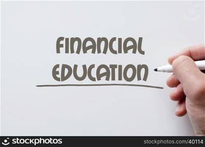 Human hand writing financial education on whiteboard