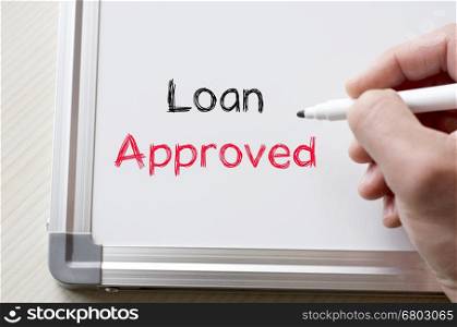 Human hand writing loan approved on whiteboard