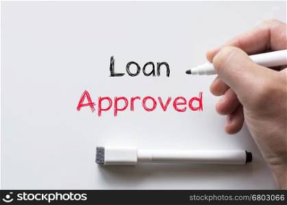 Human hand writing loan approved on whiteboard