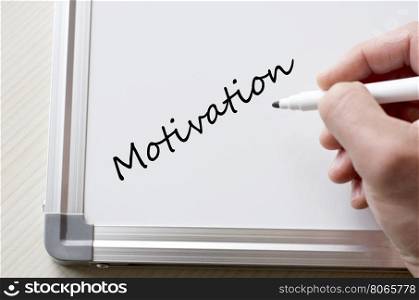 Human hand writing motivation on whiteboard