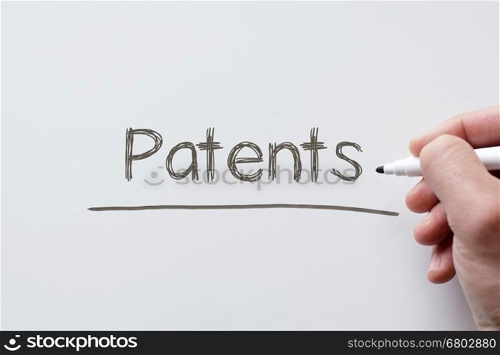 Human hand writing patents on whiteboard
