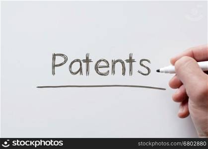 Human hand writing patents on whiteboard
