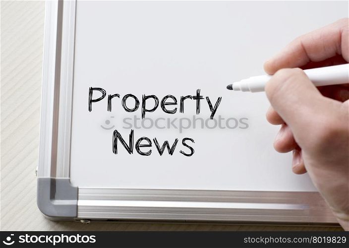 Human hand writing property news on whiteboard