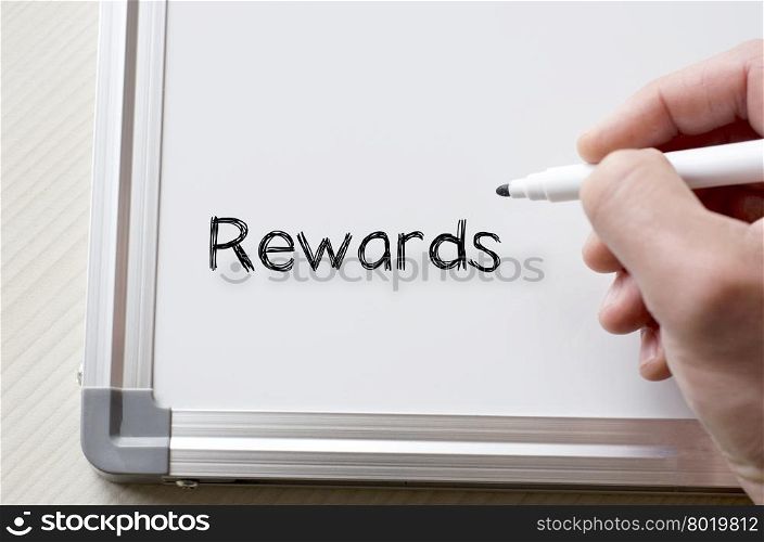 Human hand writing rewards on whiteboard