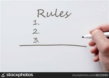 Human hand writing rules on whiteboard