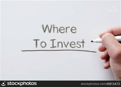Human hand writing where to invest on whiteboard