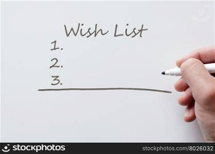 Human hand writing wish list on whiteboard