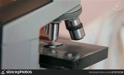 human hands are working with a microscope