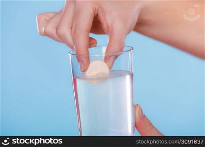 Human hands holding effervescent painkiller pill and glass of water. Health care. Headache and pain.. Hands with painkiller pill and water. Health care.