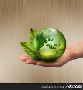 human hands holding green earth with a growing plant