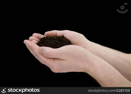 Human hands holding heart shape of soil