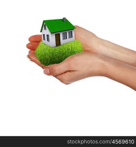 human hands holding model of a house against nature background