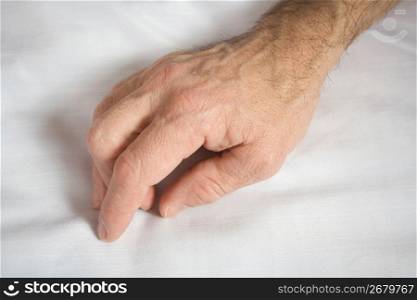 Human hands on white cloth, close-up