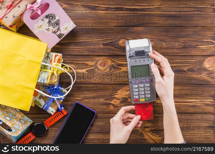 human hands using credit card swiping machine payment store