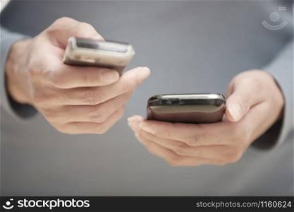 Human hands using two smartphones for data transfer