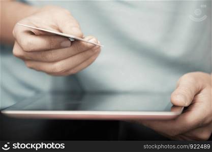 Human hands with digital tablet and credit card
