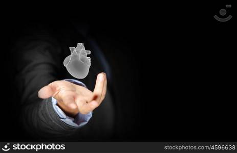 Human heart. Close up of businessman holding human heart in palm