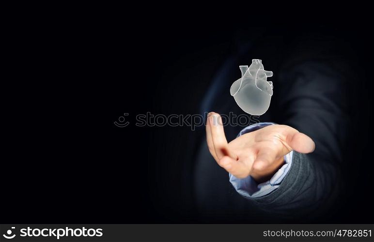 Human heart. Close up of businessman holding human heart in palm