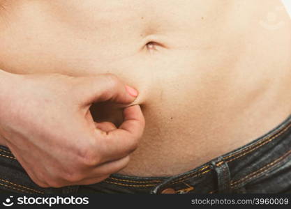 Human holding pinching fat body belly.. Closeup of human holding pinching fat body belly. Overweight cellulitis.