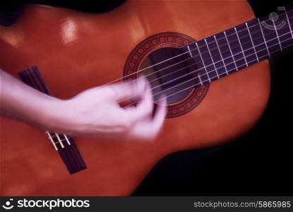 human man hand playing fast guitar detail