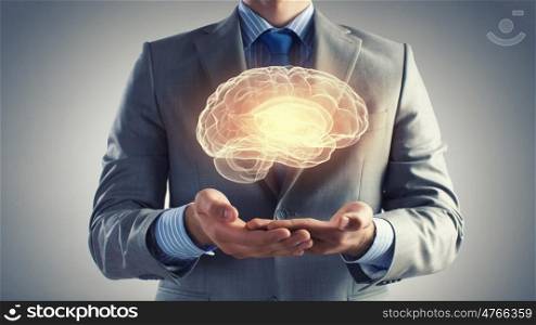 Human mind. Close up of businessman holding digital image of brain in palm