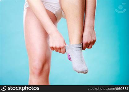 Human putting on or taking off socks. Leg foot closeup.