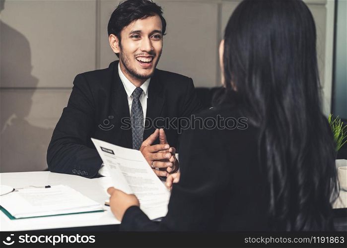 Human resource manager interviewing the male employment candidate in the office room. Happy job interview. Job application, recruitment and Asian labor hiring concept.