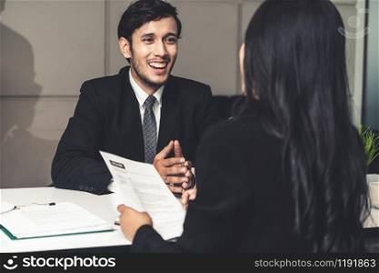 Human resource manager interviewing the male employment candidate in the office room. Happy job interview. Job application, recruitment and Asian labor hiring concept.