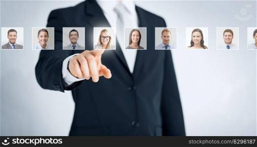 human resources, career management, recruitment and success concept - man in suit pointing to one of many business people portraits. human resources, career and recruitment concept