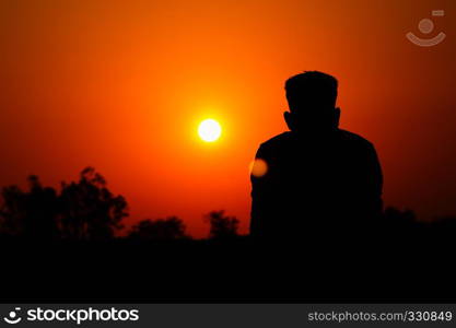 Human silhouette watching the setting sun, Satara, Maharashtra, India. Human silhouette watching the setting sun, Satara, Maharashtra, India.